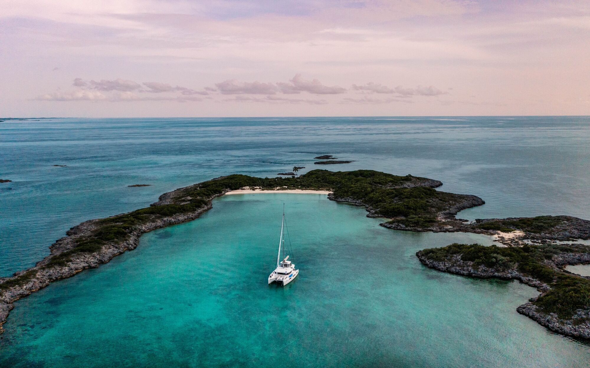 Aerial view of PurelyBlu catamaran anchored alone in turquoise Exumas waters
