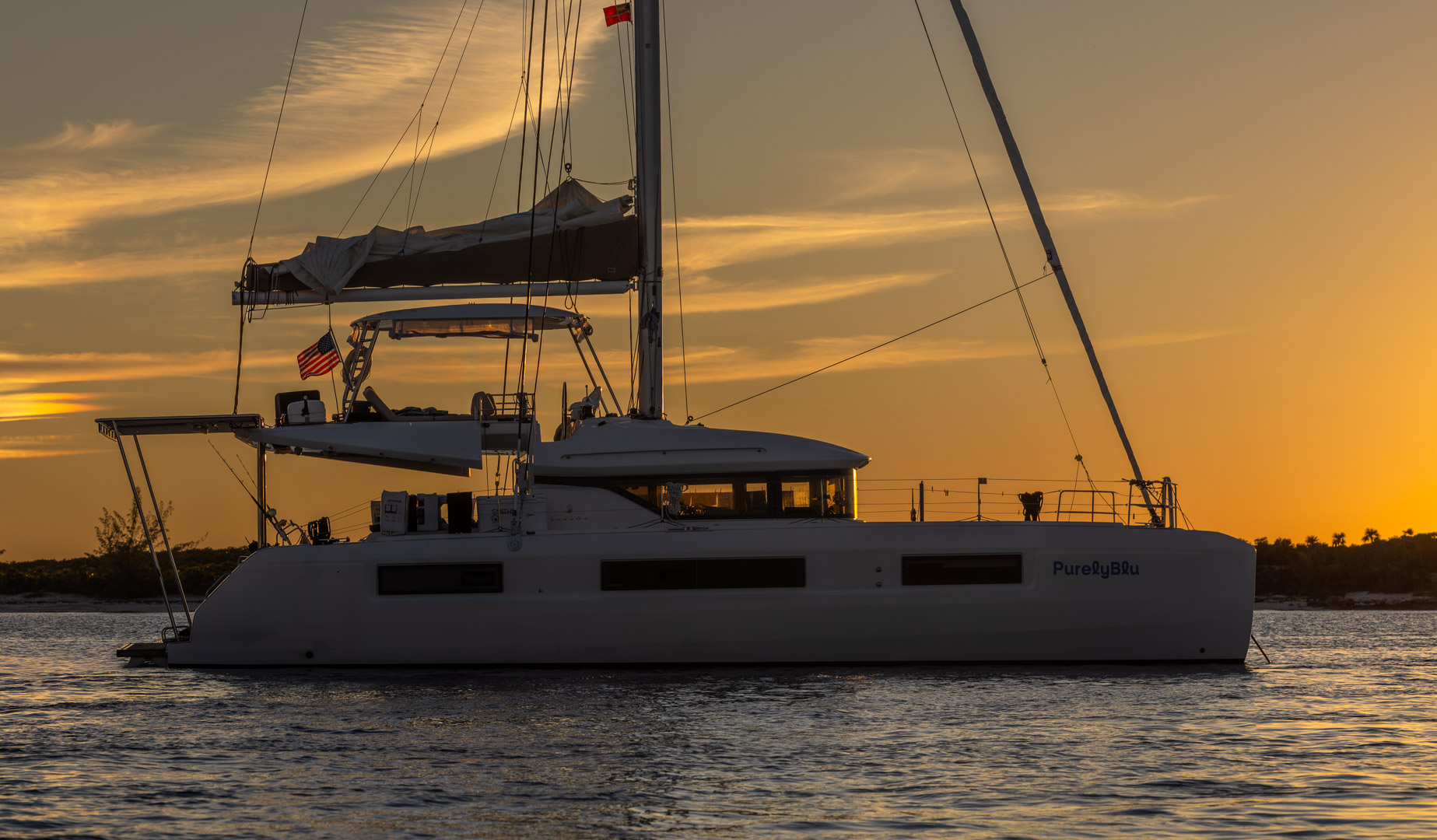 Aerial view of PurelyBlu catamaran anchored alone in turquoise Exumas waters